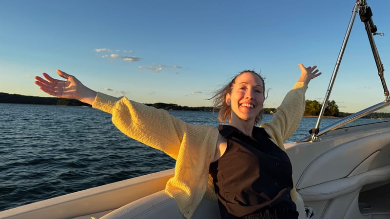 Erin Warner on a boat on a lake at dusk with new friends
